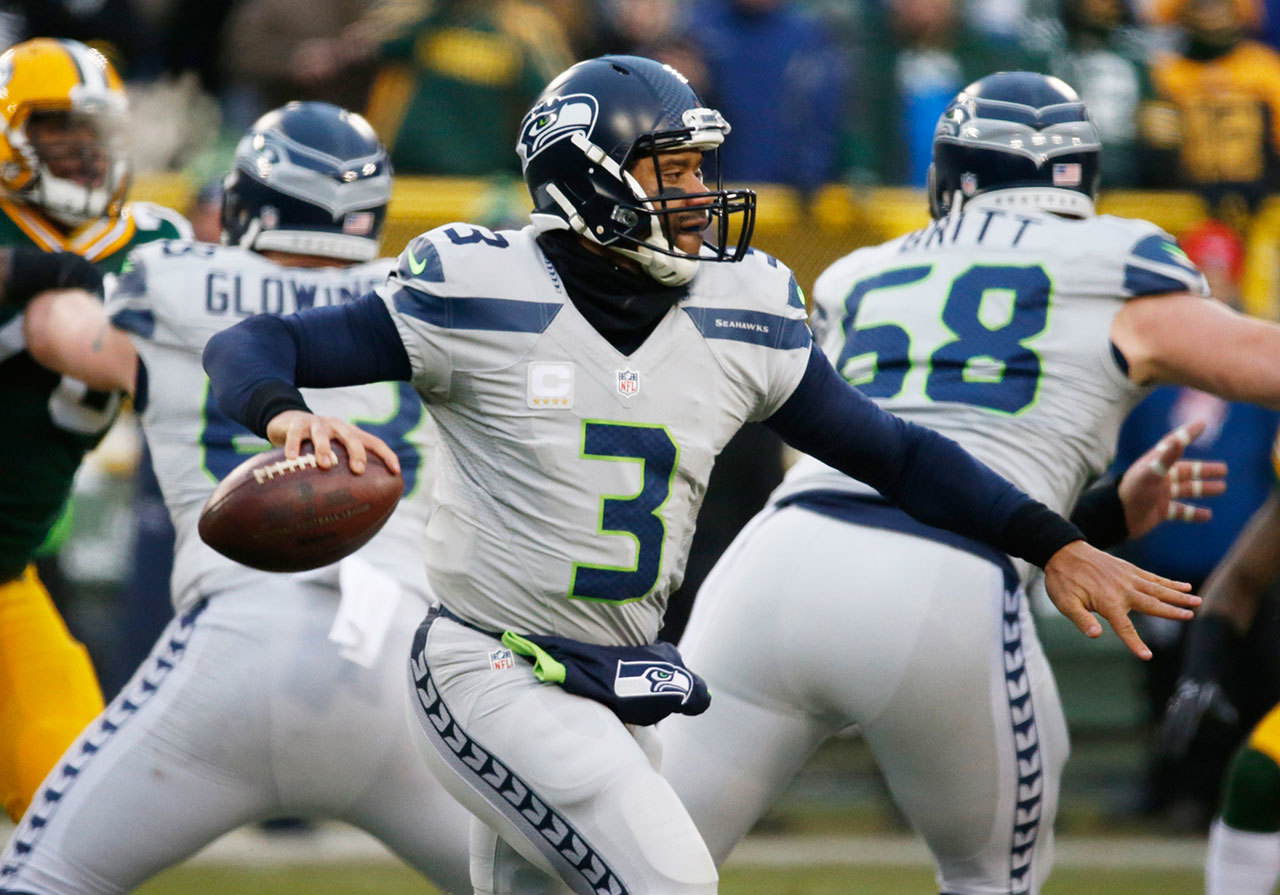 Seattle Seahawks&rsquo; Russell Wilson drops back during the first half of an NFL football game against the Green Bay last year. He is again featured in a series of commercial for Seattle-based Alaska Airlines. (File photo)