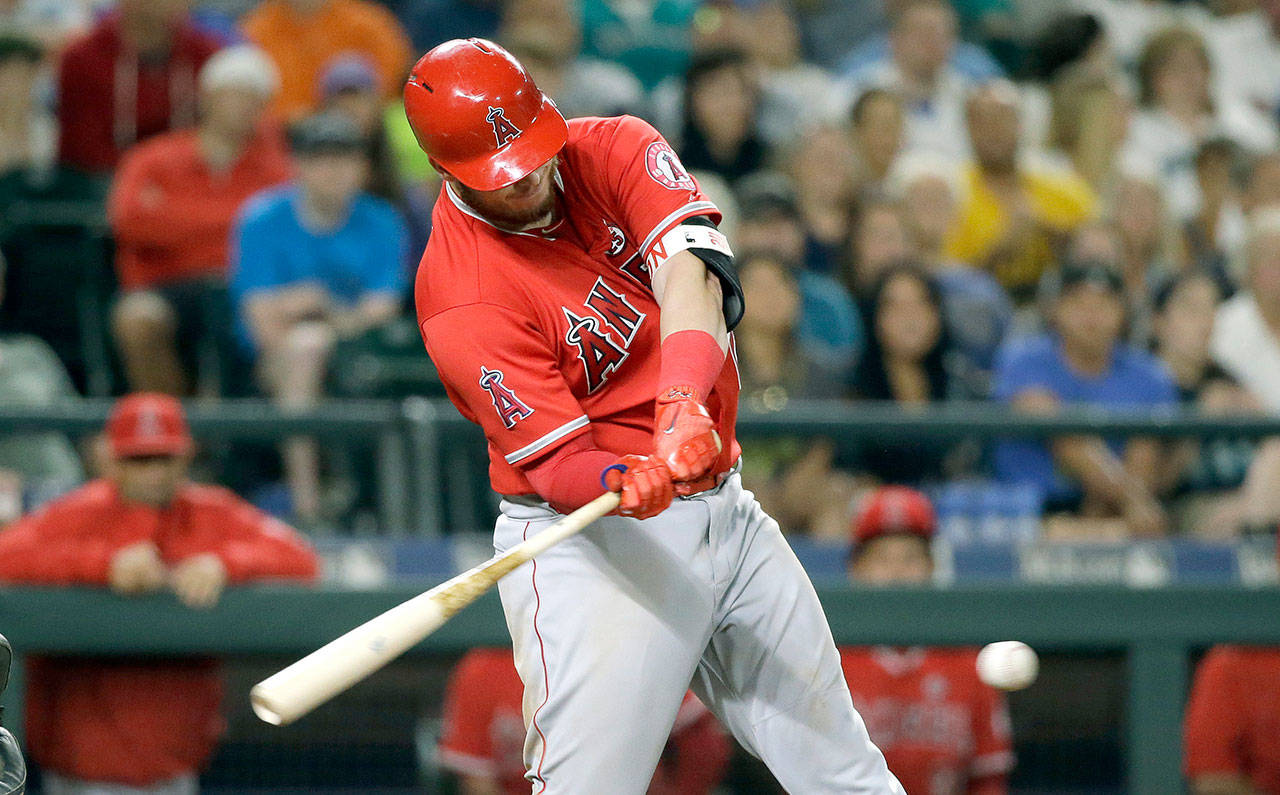 The Los Angeles Angels’ C.J. Cron hits a grounder that was bobbled by Seattle shortstop Jean Segura, an error that allowed Mike Trout to score with the eventual winning run in L.A.’s 6-5 win over the Mariners on Friday in Seattle. (AP Photo/Elaine Thompson)