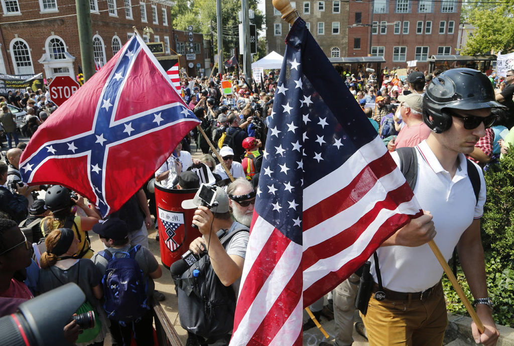 White nationalist demonstrators walk into Lee park surrounded by counter demonstrators in Charlottesville, Virginia, on Saturday. (AP Photo/Steve Helber)
