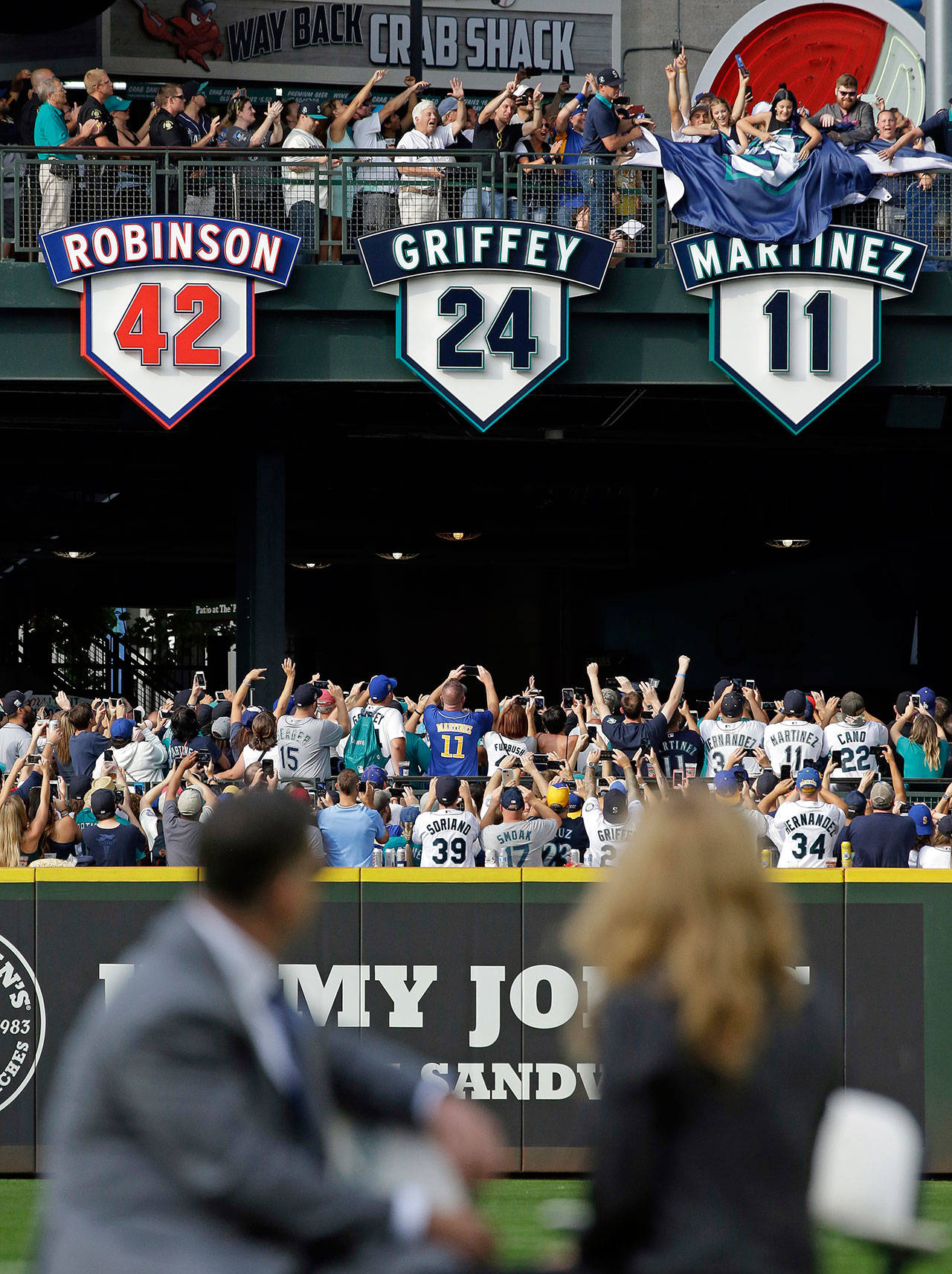 Edgar Martinez (left) sits with his wife Holli Martinez as they watch the unveiling of his No. 11 during a ceremony before Saturday’s game in Seattle. (AP Photo/Elaine Thompson)