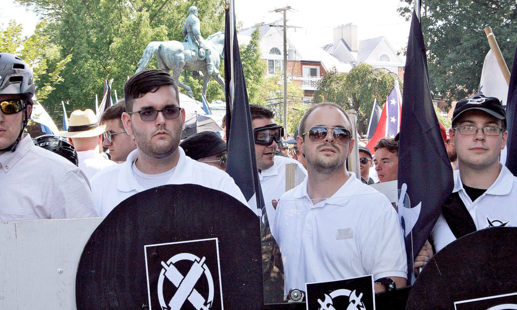 James Alex Fields Jr. (second from left) holds a black shield on Saturday in Charlottesville, Virginia, at the white supremacist rally. Fields was later charged with second-degree murder and other counts after authorities say he plowed a car into a crowd of people protesting the rally. (Alan Goffinski via AP)
