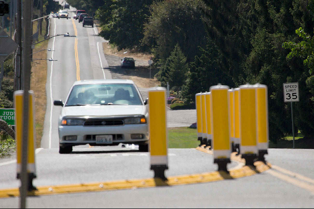 A raised curb and 14 reflective and flexible delineator posts steer drivers to the right changes at the intersection where Broadway takes a sharp right turn over a short bridge, south of 41st Street, on Tuesday in Everett. (Andy Bronson / The Herald)