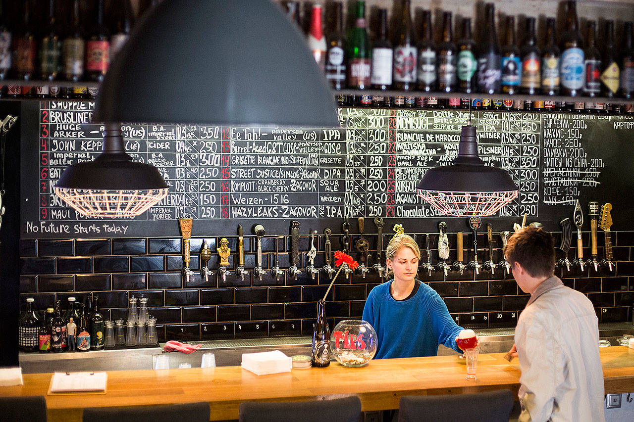 People enjoy craft beer at the Rule Taproom pub in Moscow on July 21.. Pint by frothy pint, a hoppy revolution is brewing in Russia. A new generation of craft beer brewers began sprouting in the vodka capital of the world as foreign beers got too expensive and beer-drinkers started looking for alternatives to mass-produced lagers. (AP Photo / Alexander Zemlianichenko)