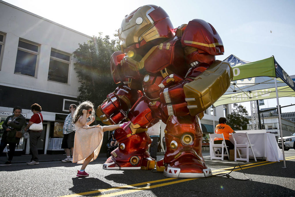 Mikaelin Hann, 6, of Everett, gives a gigantic Iron Man toy a playful kick during the grand opening of Funko in downtown Everett on Saturday. (Ian Terry / The Herald)
