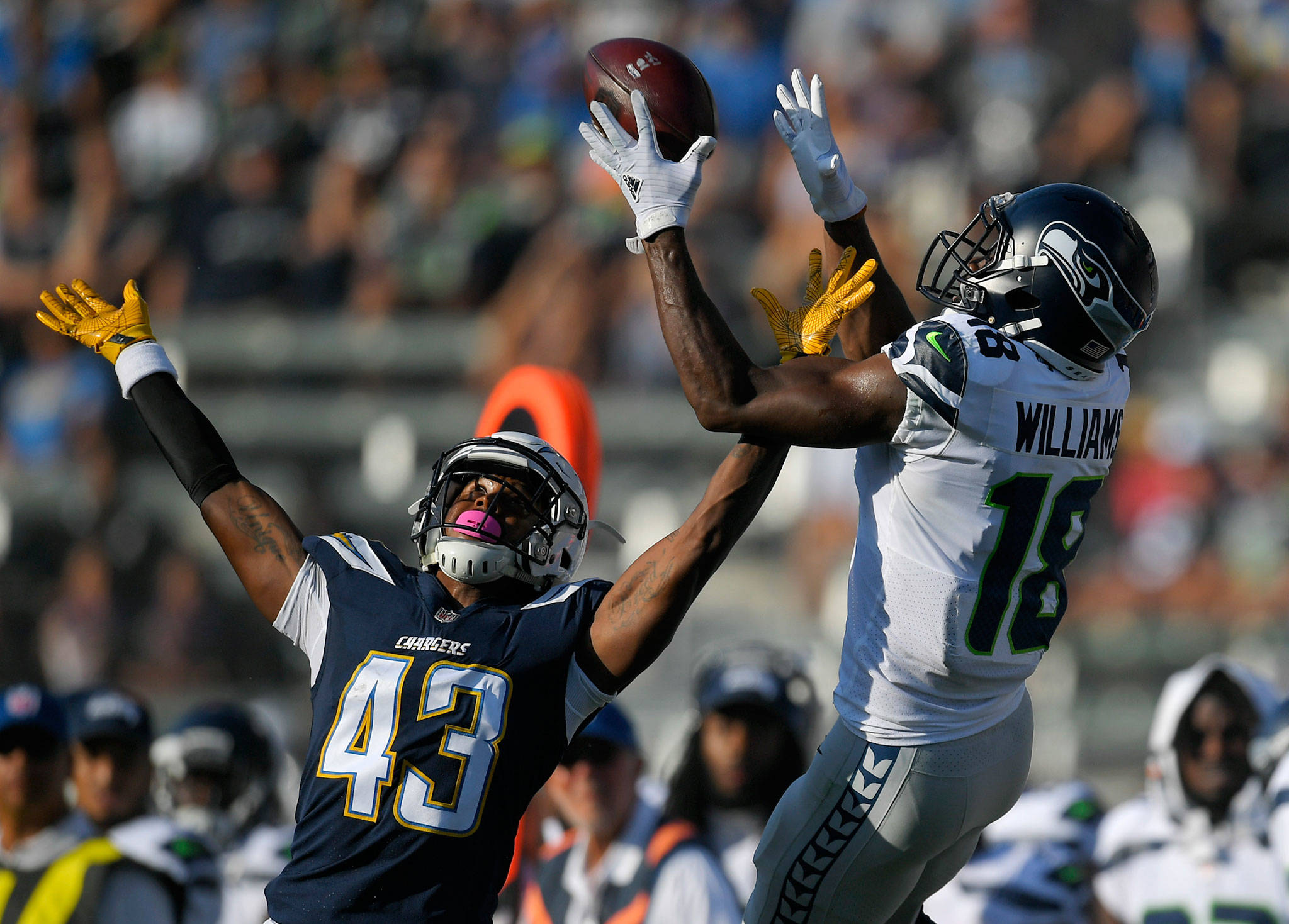 Seattle Seahawks wide receiver Kasen Williams (18) makes a catch over Los Angeles Chargers cornerback Michael Davis (43) during the first half of an NFL preseason football game Sunday, Aug. 13, 2017, in Carson, Calif. (AP Photo/Mark J. Terrill)