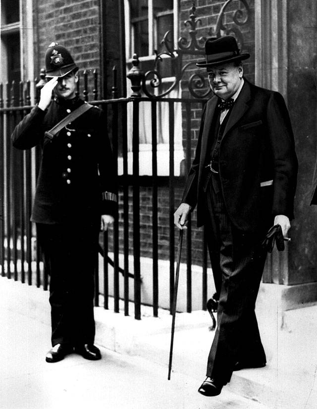 A police officer salutes as British Prime Minister Winston Churchill leaves 10 Downing St. in London, England, on Aug. 20, 1940. Churchill was on his way to the House of Commons, where he paid tribute to the Royal Air Force, saying, “Never in the field of human conflict was so much owed by so many to so few.” (Associated Press)