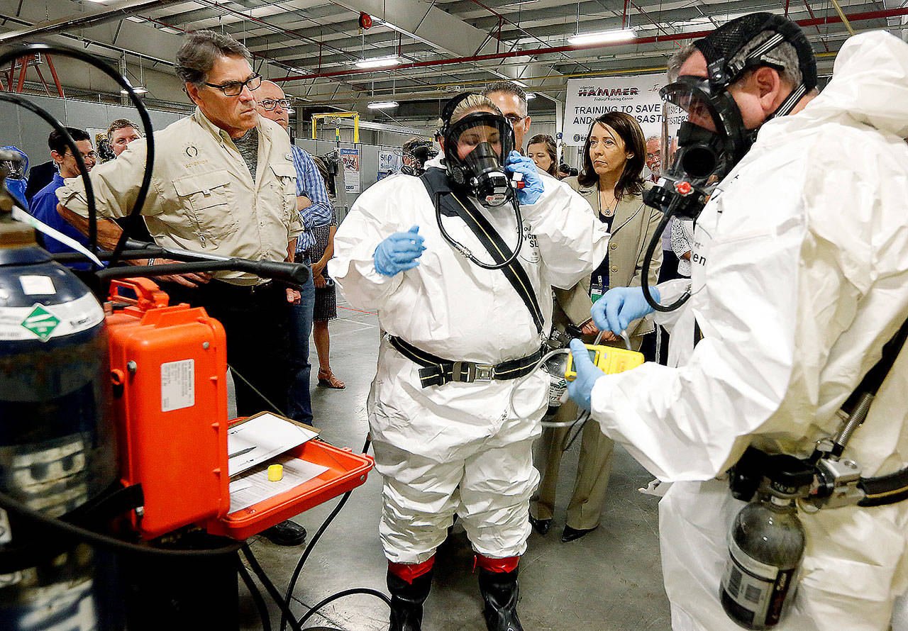 Energy Secretary Rick Perry (left) watches as worker trainers Joni Spencer (center) and Dean Beaver prepare to give a respirator demonstration on Tuesday at the HAMMER Training Facility in Richland. The federal facility offers a wide variety of training to Hanford Nuclear Reservation workers. Rep. Greg Walden, R-Ore., stands next to Perry, and U.S. Sen. Maria Cantwell, D-Wash., stands in between the workers, at right. (Bob Brawdy/Tri-City Herald via AP)