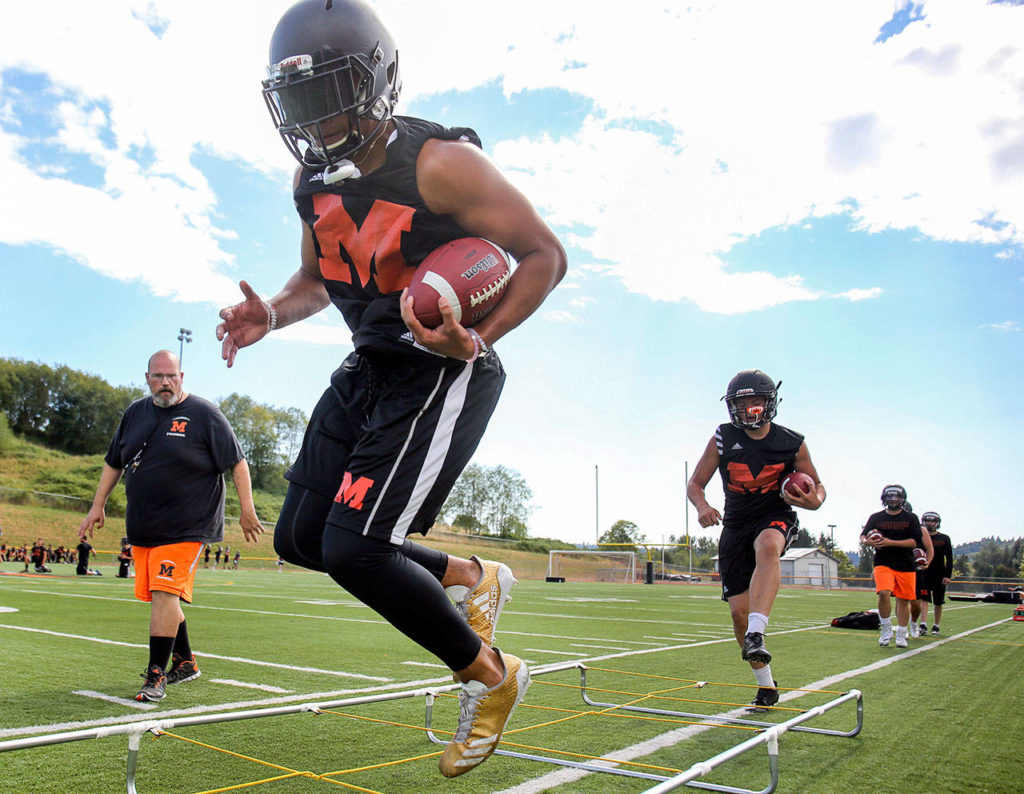 Monroe’s Isaiah Lewis (left) and Blake Rybar (following) work through agility drills during practice on Aug. 16, 2017, at Monroe High School. (Kevin Clark / The Herald)
