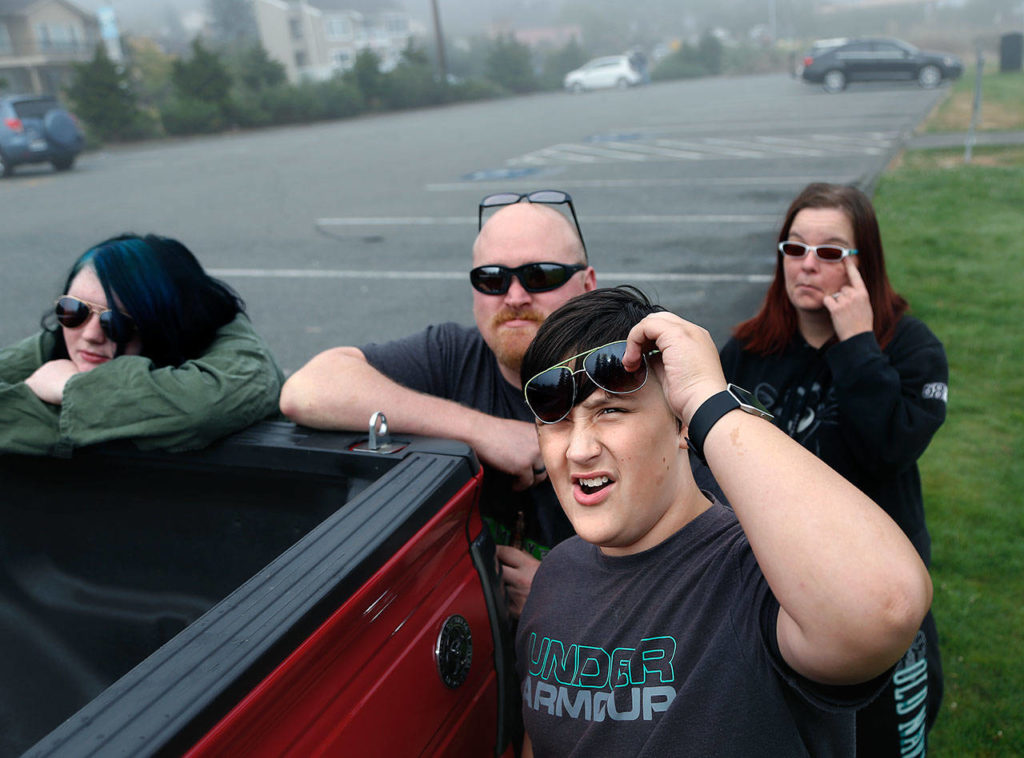 At Harborview Park in Everett, Makayla Deane, 14, Brian Dean, Jalen Kirk, 14, and Becca Carney all wait — as patiently as they can — for the fog to lift so they can see the solar eclipse on Monday morning. (Dan Bates / The Herald)
