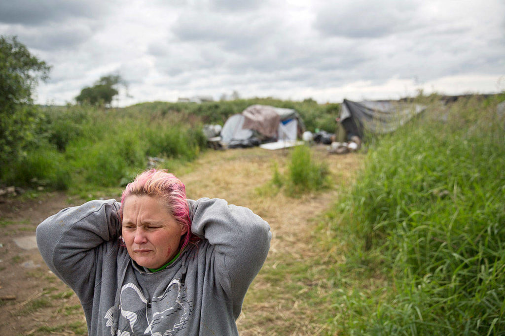 Misty Micheau Bushnell looks over the memorial marking the spot where her boyfriend, Shawn Vann Schreck, died two days before in a homeless encampment, where they live along the river in Aberdeen, on June 14. (AP Photo/David Goldman)
