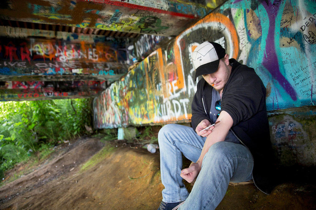 Forrest Wood, 24, injects heroin into this arm under a bridge along the Wishkah River at Kurt Cobain Memorial Park in Aberdeen on June 13. (AP Photo/David Goldman)

