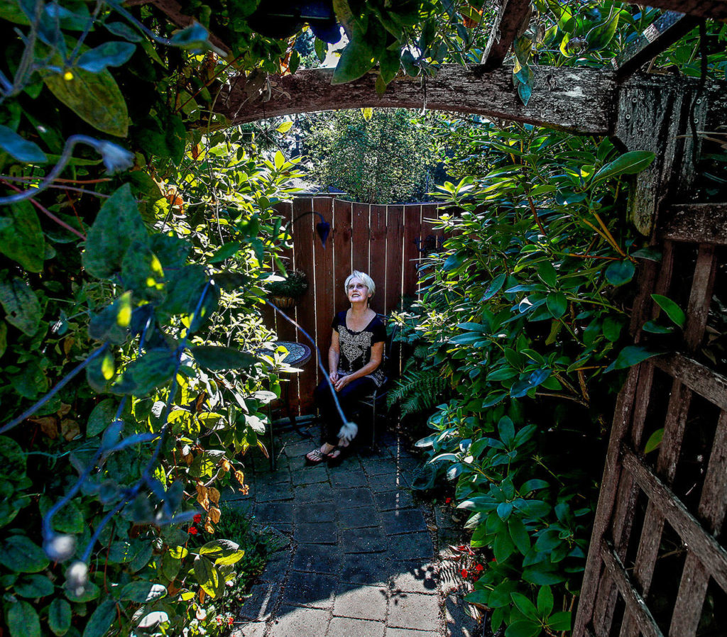 A fan of Frances Hodgson Burnett’s novel “The Secret Garden,” retired teacher Susan is happy to have a small version to call her own near a corner in the backyard garden. (Dan Bates / The Herald)
