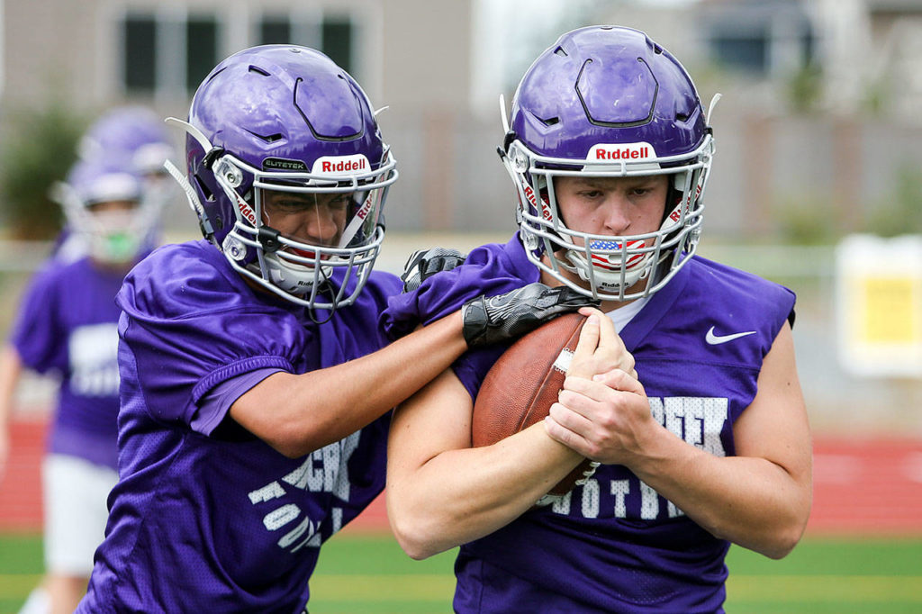 Sohin Mehta, left, works to free the ball from Kristian Brusa during practice Friday afternoon at North Creek High School in Bothell on August 18, 2017. (Kevin Clark / The Herald)
