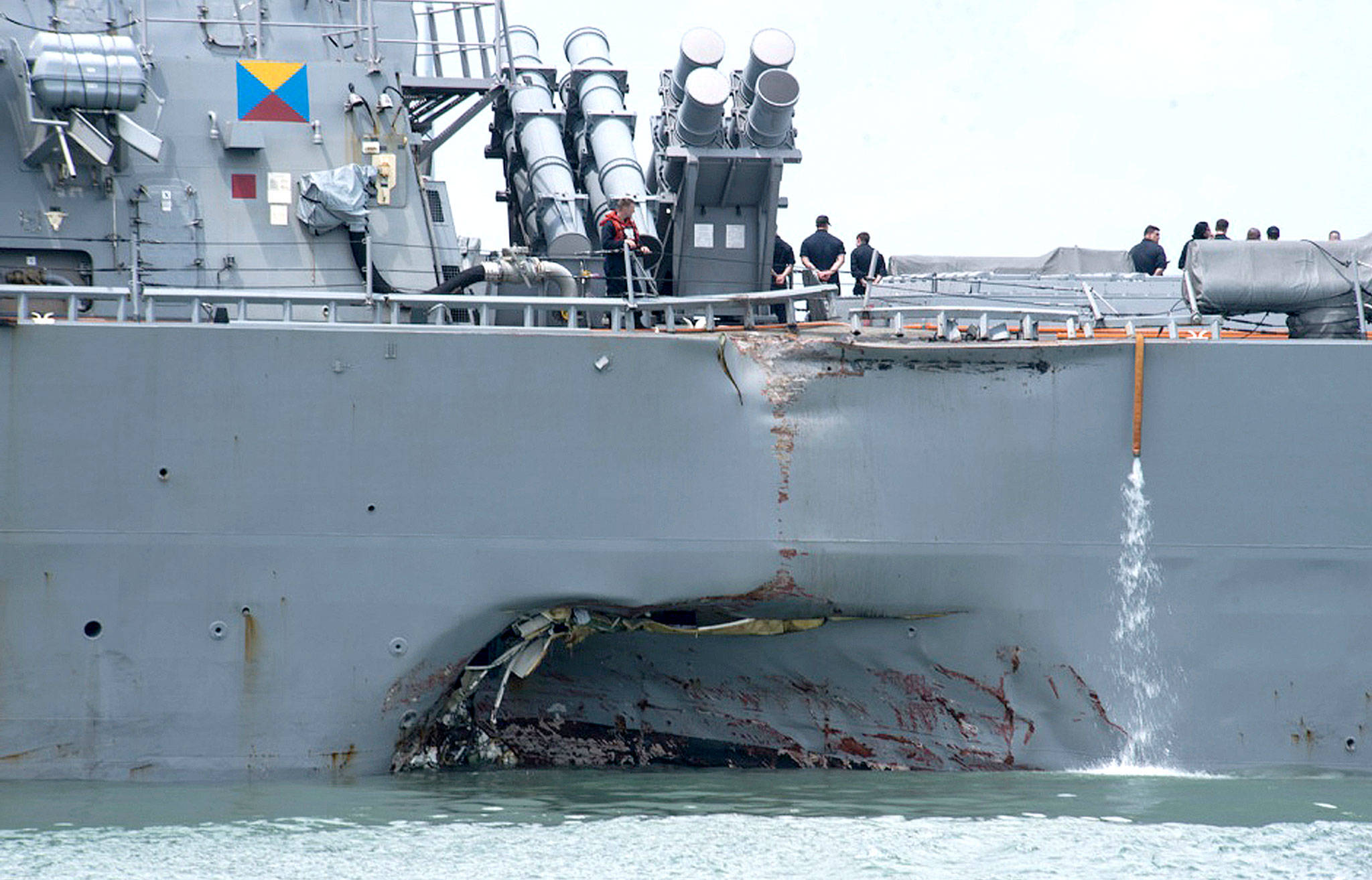 Damage to the port side is visible on Monday as the guided-missile destroyer USS John S. McCain (DDG 56) steers toward Changi naval base in Singapore after a collision with the merchant vessel Alnic MC. (Mass Communication Specialist 2nd Class Joshua Fulton/U.S. Navy photo via AP)