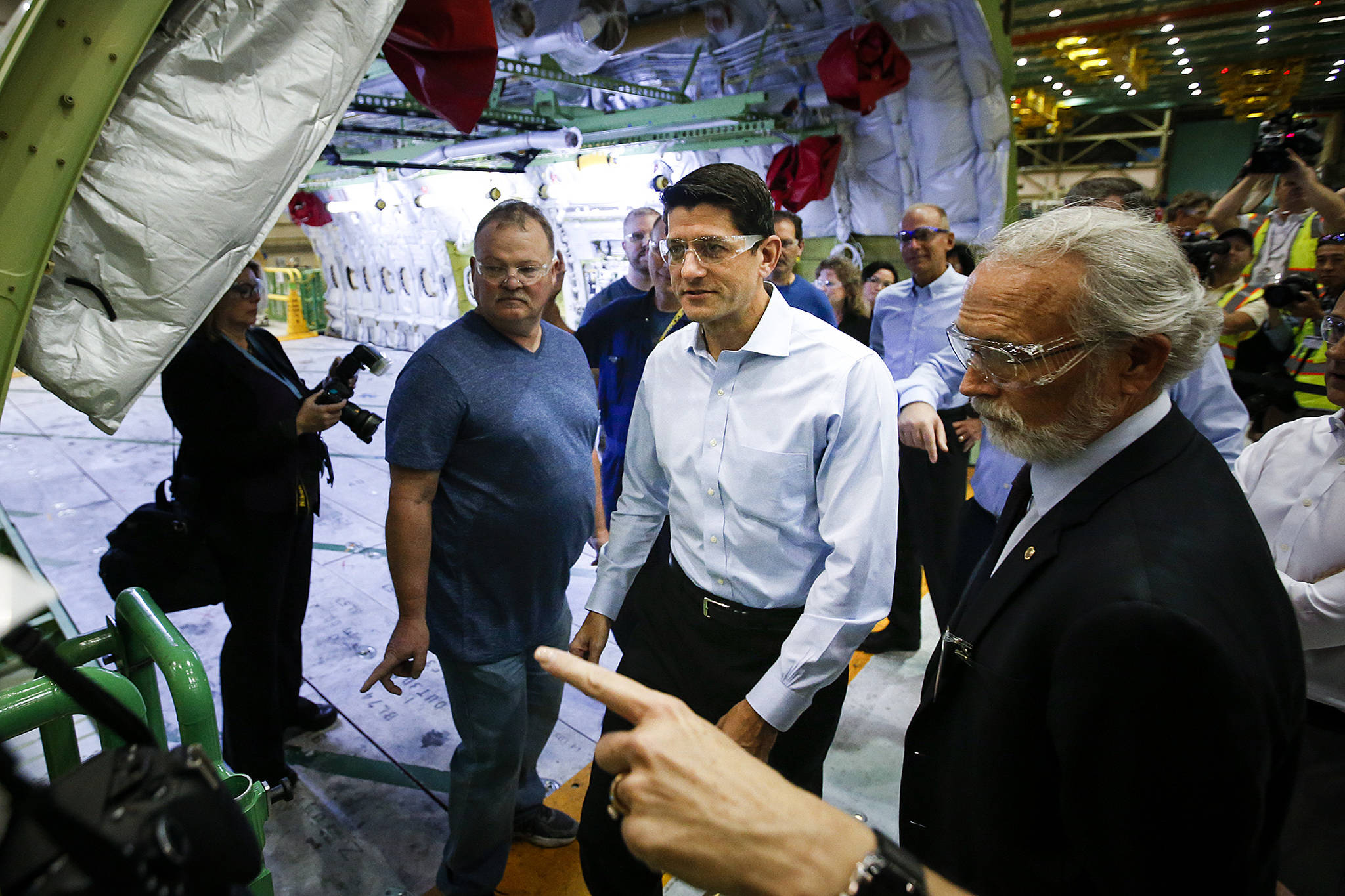 House Speaker Paul Ryan (center) walks near the midsection of a 777 fuselage during a tour of the Boeing factory on Thursday in Everett. (Ian Terry / The Herald)