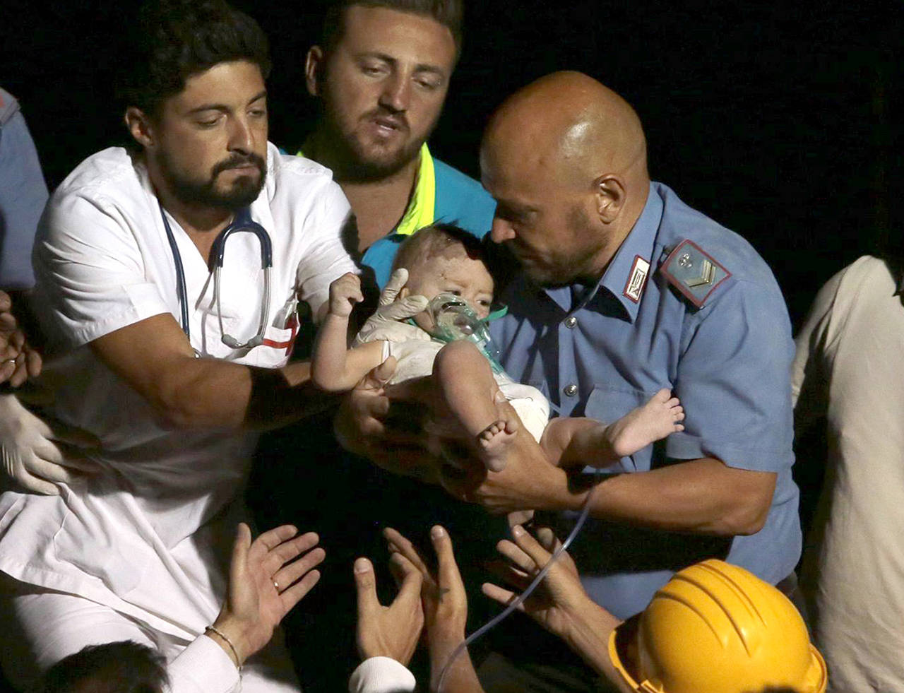 Rescuers pull out a 7-month-old boy, Pasquale, from the rubble of a collapsed building in Casamicciola, on the island of Ischia, near Naples, Italy, a day after a 4.0-magnitude quake hit the Italian resort island on Tuesday. (ANSA via AP)