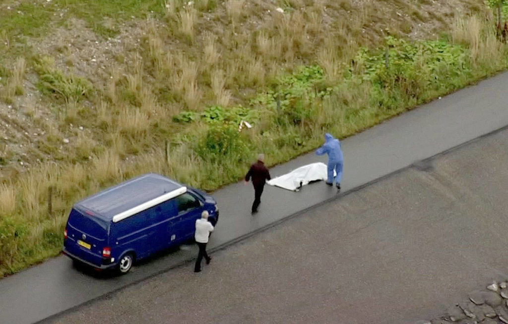 Police forensic investigators prepare to move thes body of a woman that was found near Amager, Denmark, on the Baltic Sea, where a missing Swedish journalist is believed to have died on a privately built submarine earlier this month. (TV2 via AP)
