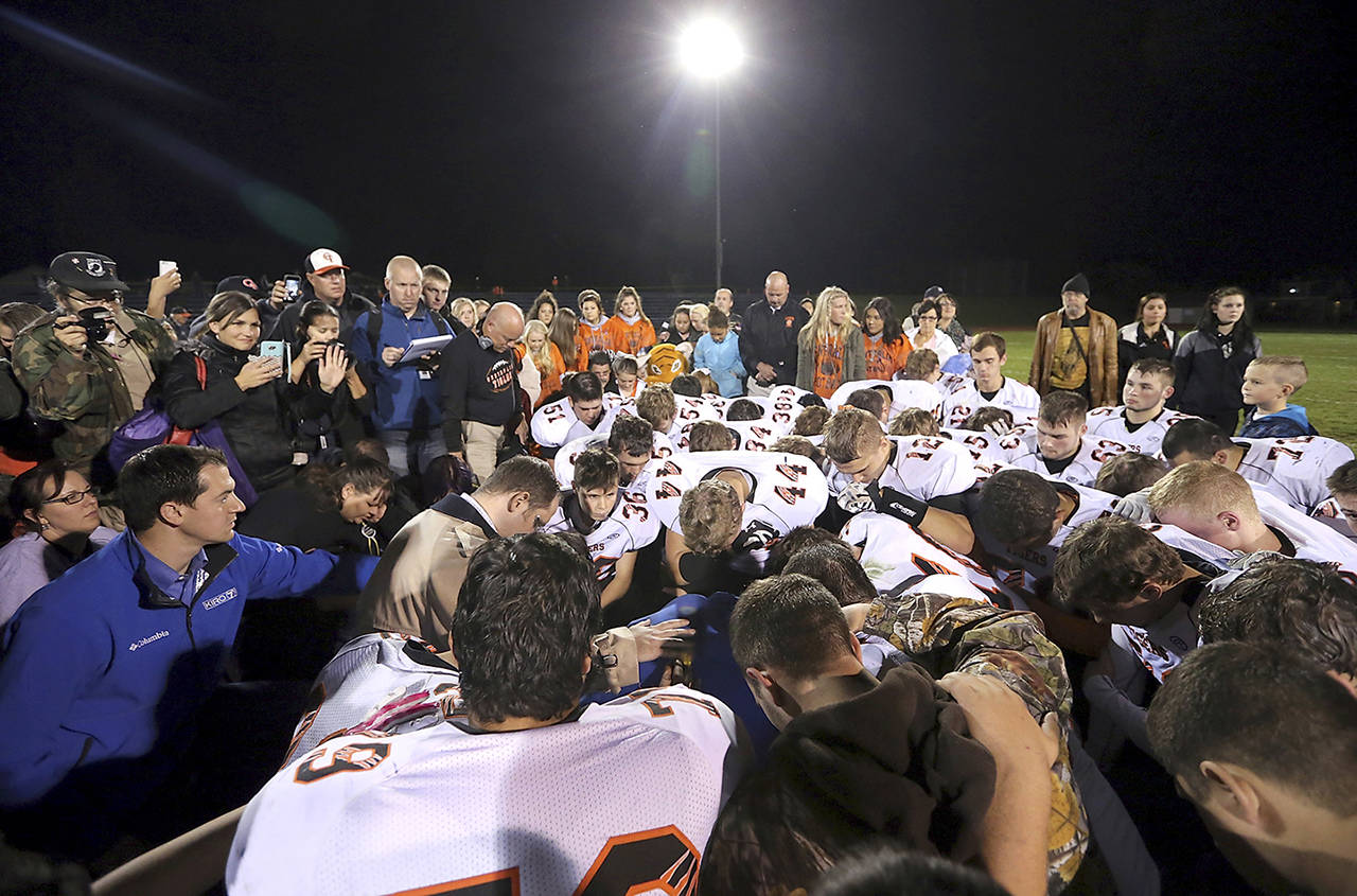 In this 2015 photo, former Bremerton High School assistant football coach Joe Kennedy, obscured at center, is surrounded by Centralia High School football players in Bremerton. (Meegan M. Reid/Kitsap Sun via AP)