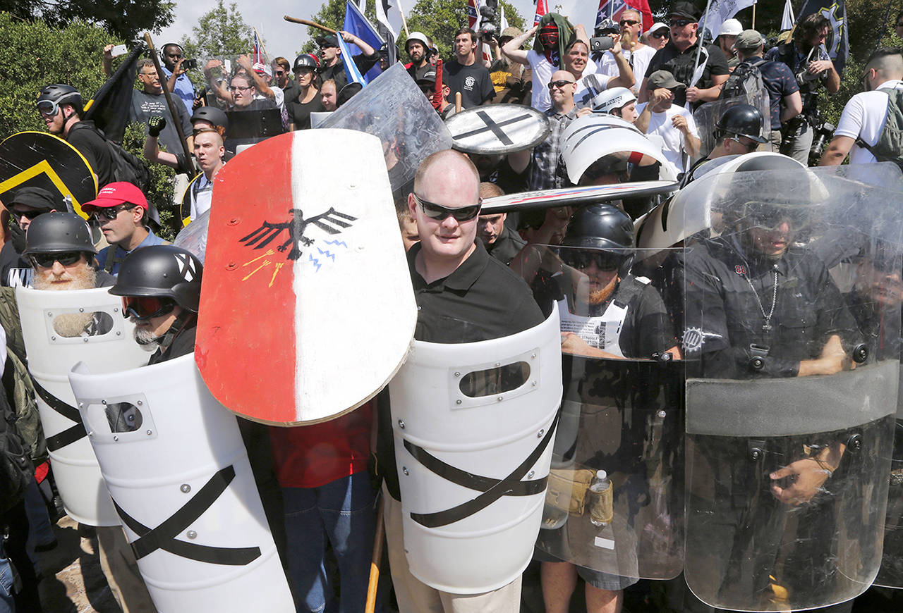 In this Aug. 12 photo, white nationalist demonstrators use shields as they guard the entrance to Lee Park in Charlottesville, Virginia. (AP Photo/Steve Helber, File)
