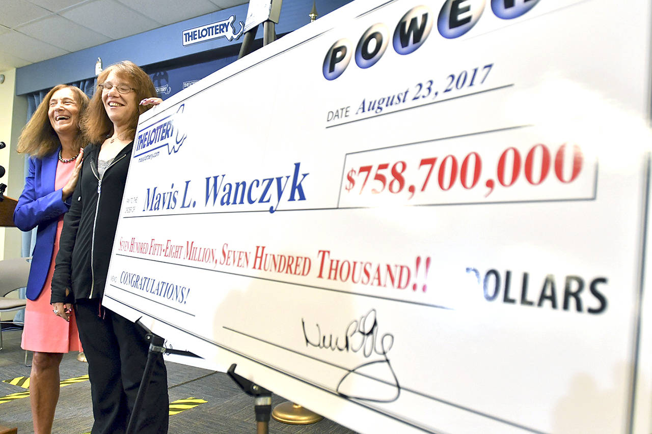 Mavis Wanczyk, of Chicopee, Massachusetts, stands by a poster of her winnings during a news conference where she claimed the $758.7 million Powerball prize at Massachusetts State Lottery headquarters. (AP Photo/Steven Senne)
