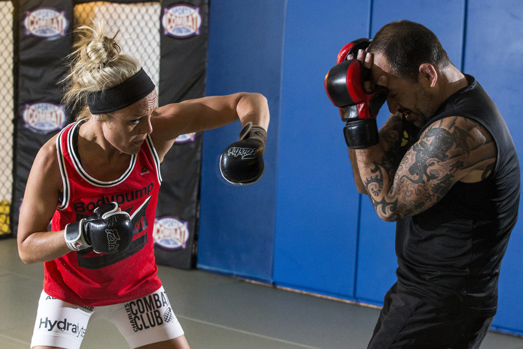 Miranda Granger (left) goes through a training routine with Charlie Pearson at Charlie’s Combat Club in Everett on Aug. 16. (Ian Terry / The Herald)
