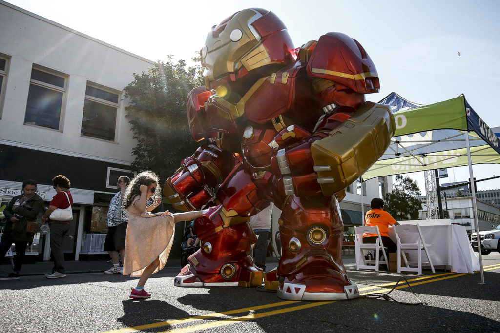 Mikaelin Hann, 6, of Everett, gives a gigantic Iron Man toy a playful kick during the grand opening of Funko in downtown Everett on Aug. 19. (Ian Terry / The Herald)
