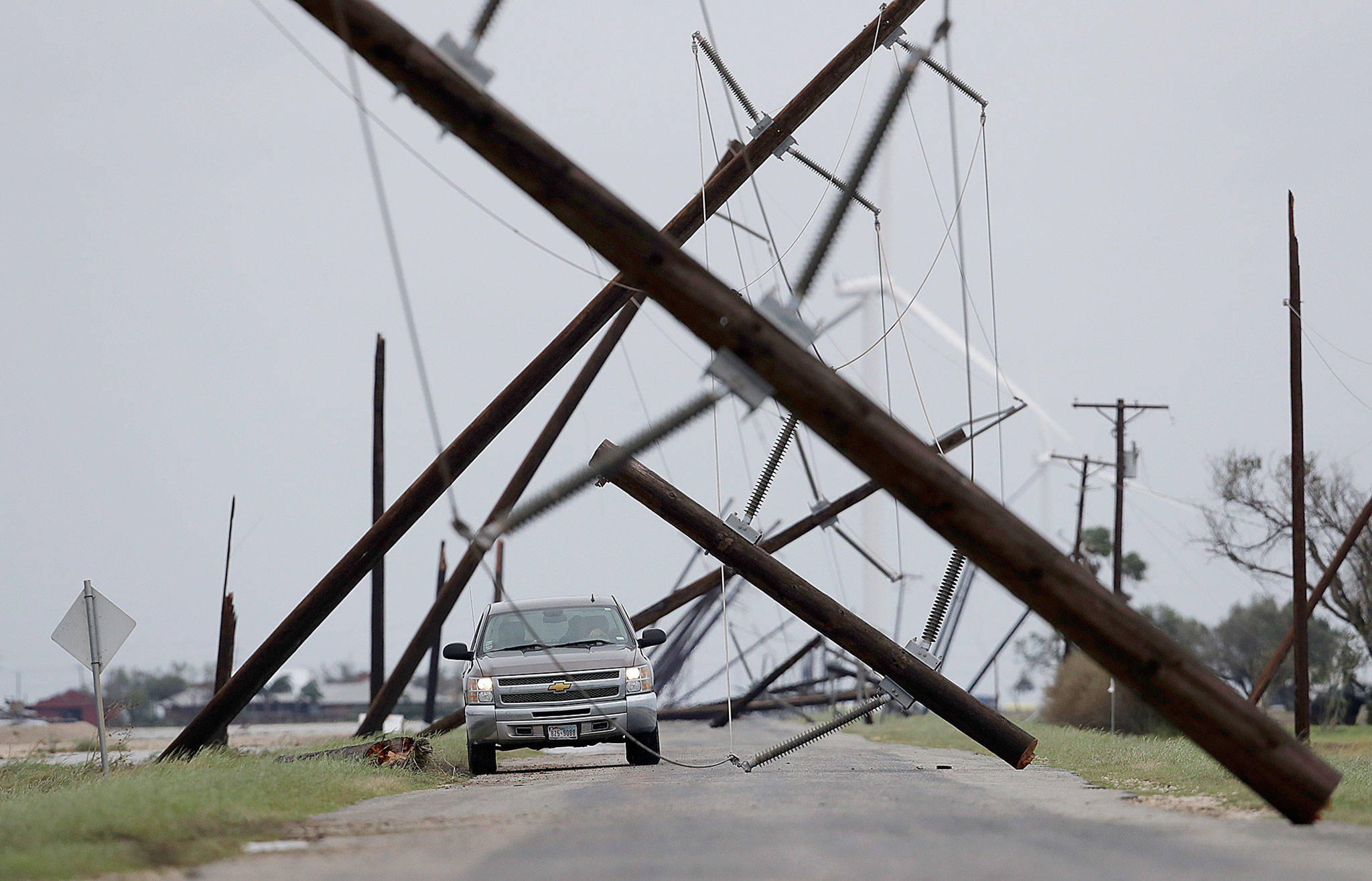 A driver works his way through a maze of fallen utility poles damaged in the wake of Hurricane Harvey on Saturday in Taft, Texas. (AP Photo/Eric Gay)