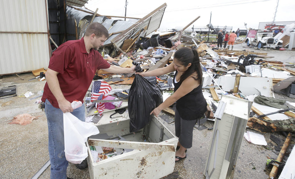 Kenneth Byrant and his wife, Jennifer Byrant, search through debris from Bryant’s Auto Sales in Katy, Texas, after a possible tornado during Hurricane Harvey on Saturday. They were looking for cars keys and paperwork. (Melissa Phillip /Houston Chronicle via AP)
