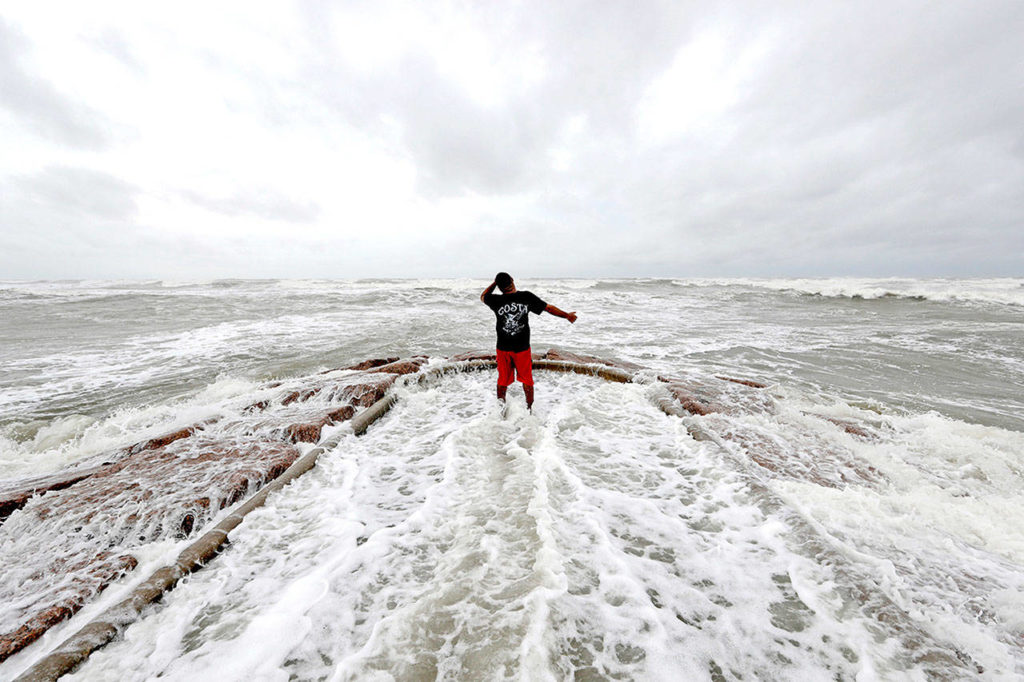 Luis Perez watches waves crash again a jetty in Galveston, Texas, as Hurricane Harvey intensifies in the Gulf of Mexico on Friday. (AP Photo/David J. Phillip)
