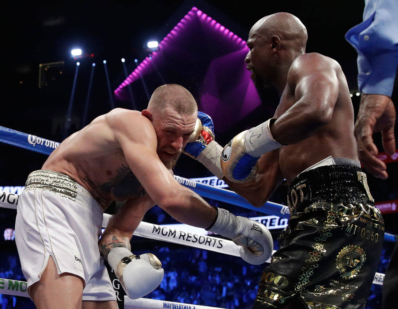 Floyd Mayweather Jr. hits Conor McGregor in a super welterweight boxing match Aug. 26, 2017, in Las Vegas. Mayweather won by TKO in the 10th round. (AP Photo/Isaac Brekken)