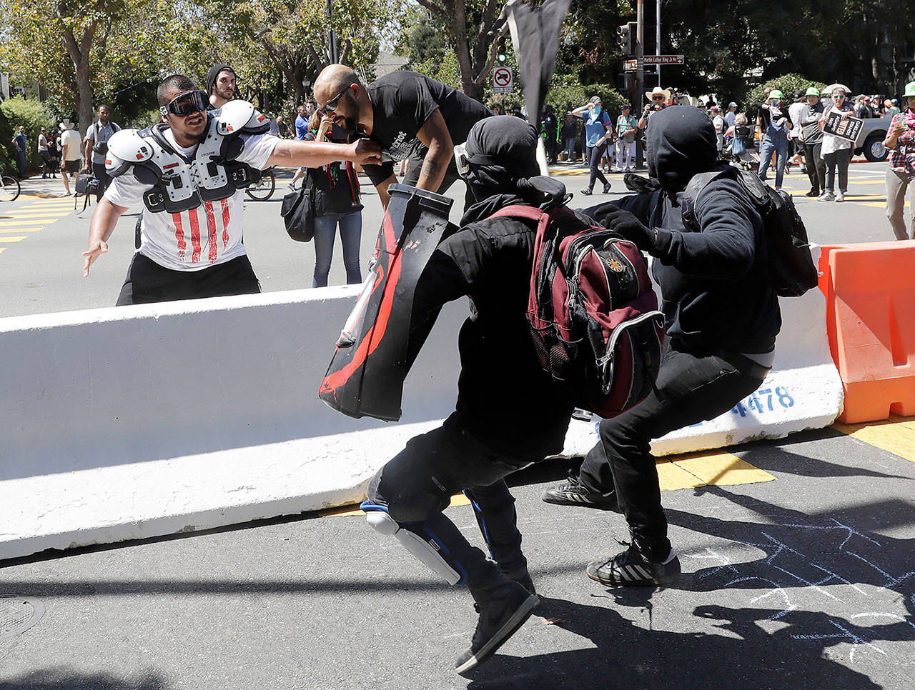 Demonstrator Joey Gibson (second from left) is chased by anti-fascists during a free speech rally Sunday in Berkeley, California. (AP Photo/Marcio Jose Sanchez)
