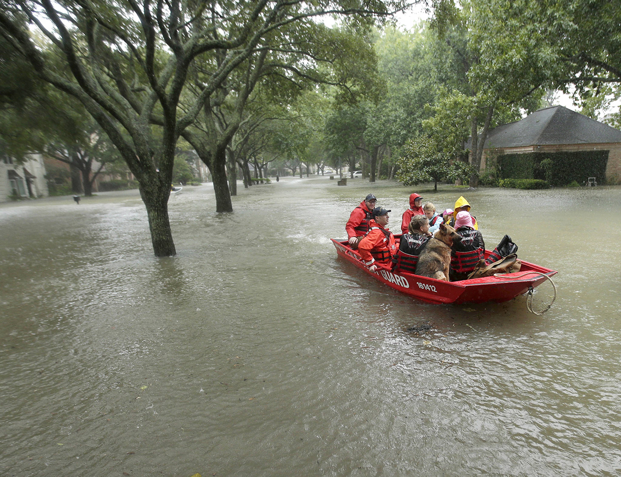 A Coast Guard rescue team evacuates people from a neighborhood inundated by floodwaters from Tropical Storm Harvey on Monday in Houston, Texas. (AP Photo/Charlie Riedel)