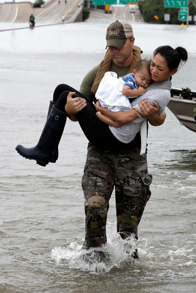 Houston Police SWAT officer Daryl Hudeck carries Catherine Pham and her 13-month-old son Aiden after rescuing them from their home surrounded by floodwaters from Tropical Storm Harvey on Sunday in Houston. (AP Photo/David J. Phillip)
