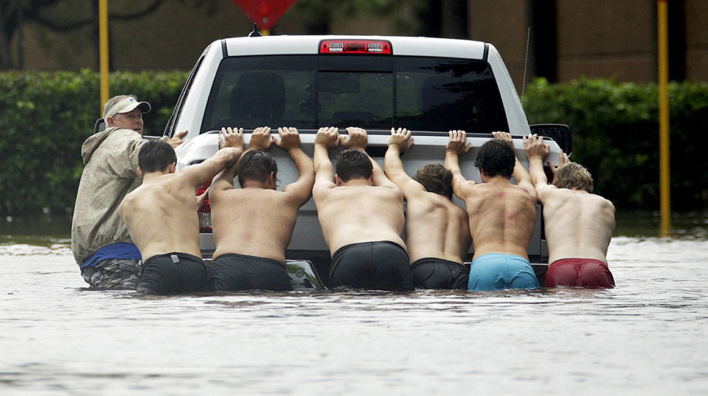 People push a stalled pickup through a flooded street in Houston, after Tropical Storm Harvey dumped heavy rains on Sunday. (AP Photo/Charlie Riedel)
