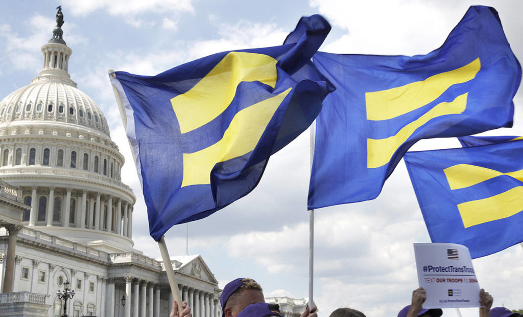 In this July 26 photo, people with the Human Rights Campaign hold up “equality flags” during an event on Capitol Hill in Washington, in support of transgender members of the military. (AP Photo/Jacquelyn Martin)

