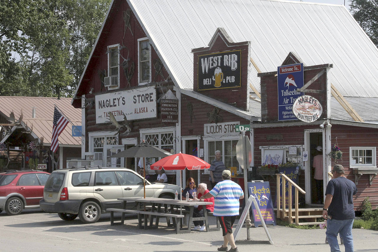 This July 12 photo shows tourists walking along historic Main Street in Talkeetna, Alaska. (AP Photo/Mark Thiessen)