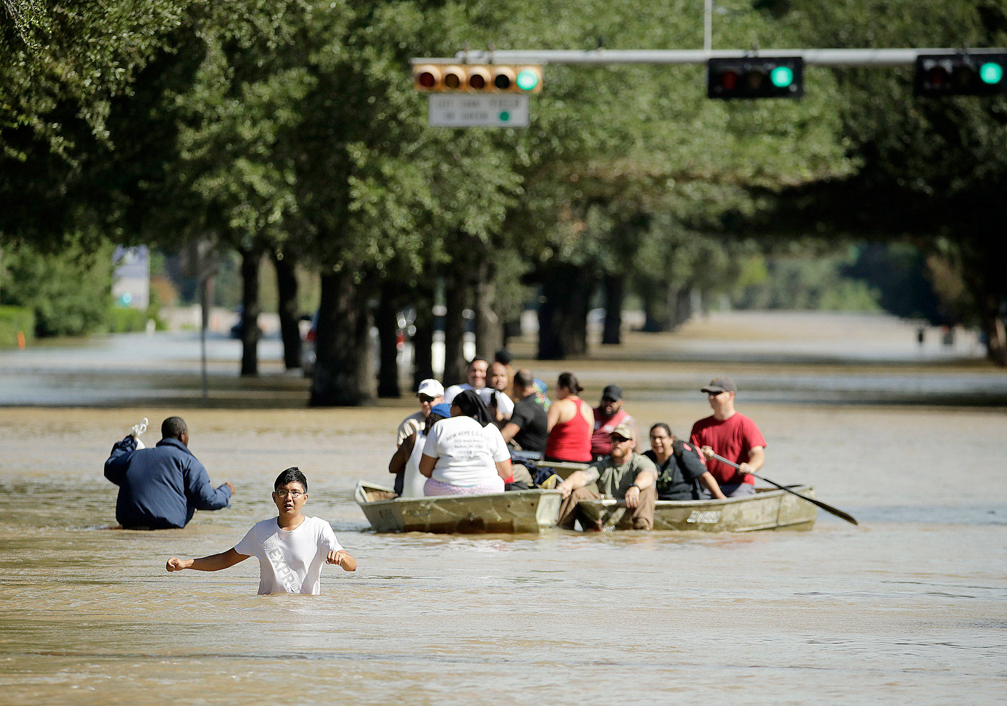 People evacuate an inundated neighborhood after water was released from nearby Addicks Reservoir when it reached capacity due to Tropical Storm Harvey on Wednesday in Houston. (AP Photo/Charlie Riedel)