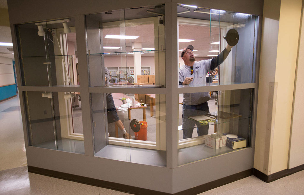 Bud Barton’s Glass’ Dan Gannan installs new windows in the library. (Andy Bronson / The Herald)
