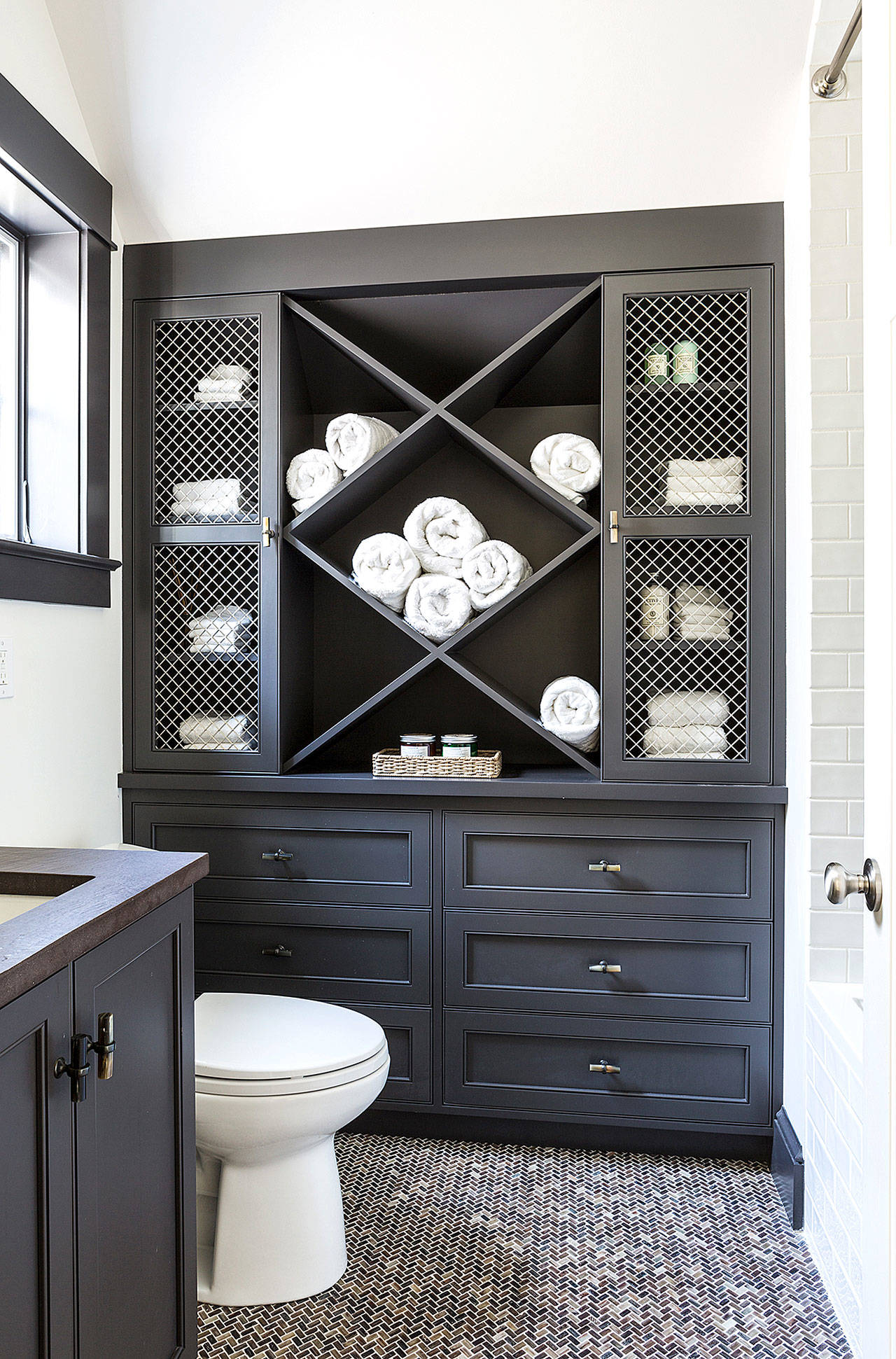 Take advantage of the vertical space in a small bathroom, designer Shazalynn Cavin-Winfrey says. A tall cabinet or a medicine cabinet over the toilet can make a big difference. (Angie Seckinger)