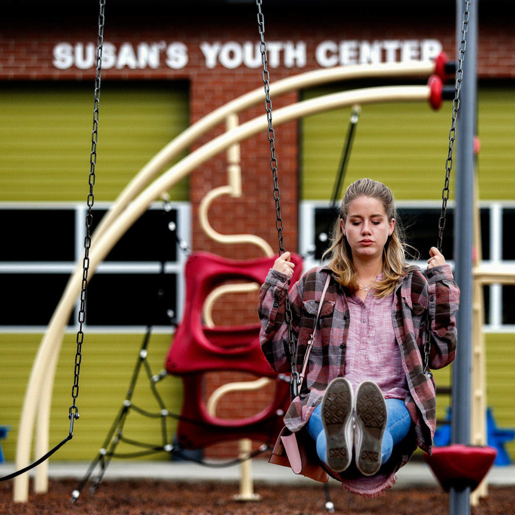 Maddy Brockert, 22, tries the swings on the playground outside Susan’s Youth Center. She has spent six years learning about domestic violence. She shared her mother’s story with middle and high school students in King County where she lives. Sen. Patty Murray invited her to join a panel to discuss how lack of funding affects domestic-violence survivors. While in college, she worked for the advocacy center on campus. (Dan Bates / The Herald)

