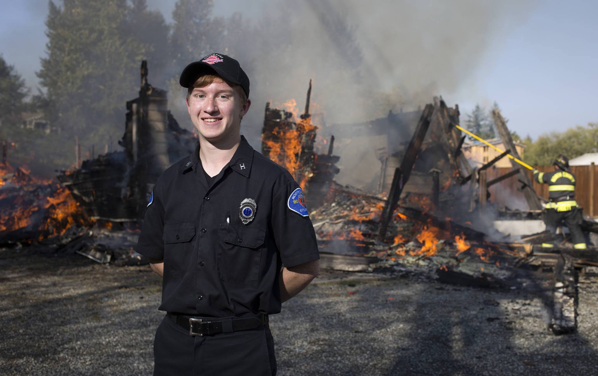 Andy Bronson / The Herald                                Wade Grant, an Explorer with North County Fire and EMS, stands in front of a practice burn Aug. 29 in Stanwood. Grant is going into the fire academy in the fall, and hopes to pursue a degree in fire science at Everett Community College.