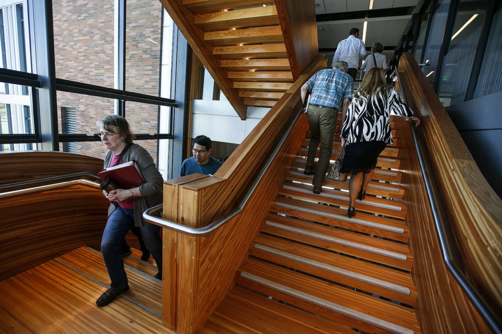 Faculty who will teach WSU medical students walk up walk up central staircase of a new building on the Everett campus where the classes will be held. The tour was on May 20. (Ian Terry / The Herald)

