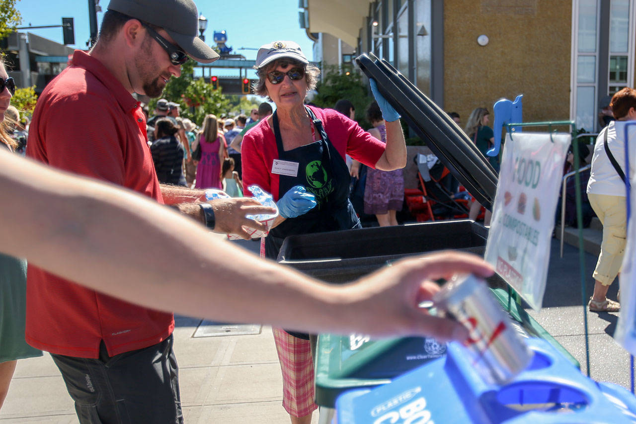 Nancy Vandenberg directs the correct sorting of waste Saturday afternoon during the Everett Food Truck festival on August 26, 2017. (Kevin Clark / The Herald)