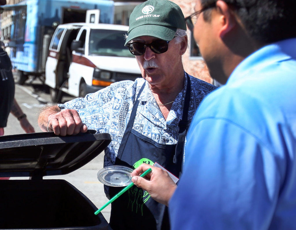 Robert Peterson directs food goers to the correct waste receptacle Saturday afternoon during the Everett Food Truck festival on August 26, 2017. (Kevin Clark / The Herald)
