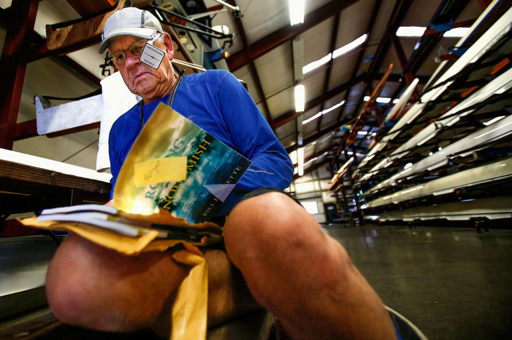 In the Everett Rowing Association shell house, Jaquette signs three books for some young rowers who found out about his book, “Rowing on the Snohomish.” (Dan Bates / The Herald)
