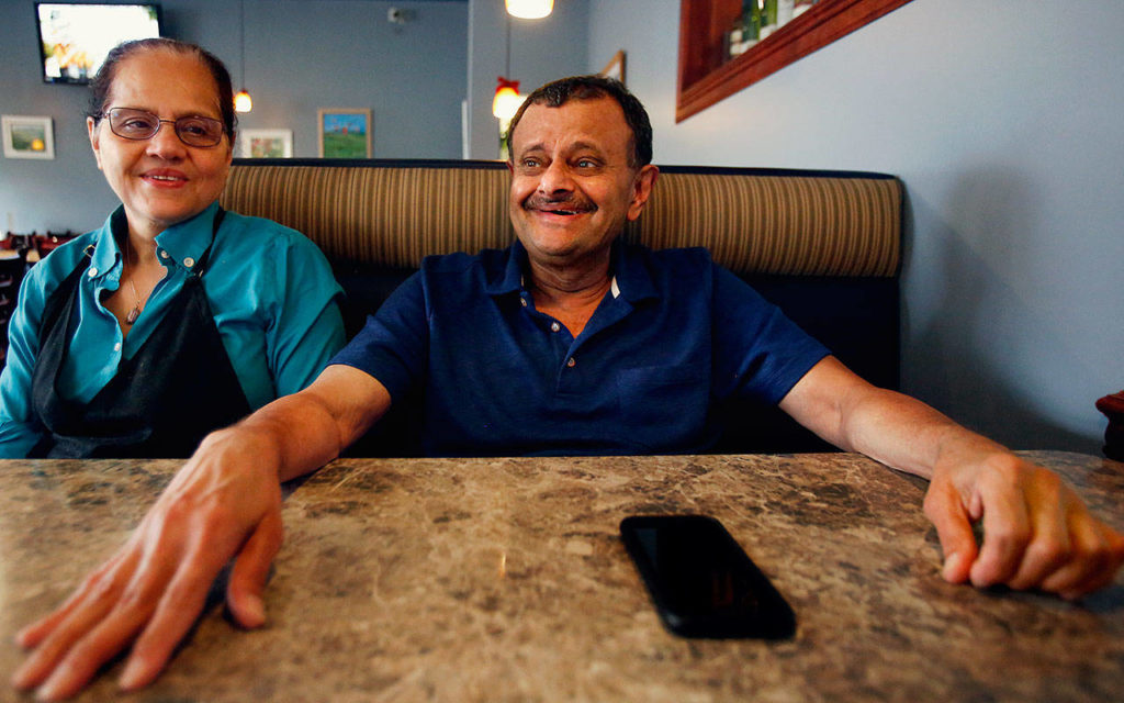 Ruqayya (left) smiles knowingly as her husband Shabbir Bala tells stories while sitting in one of their Boondockers booths Wednesday, their final day of business. (Dan Bates / The Herald)
