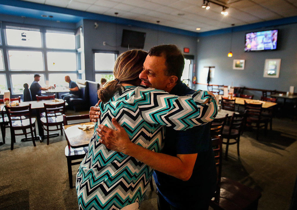Longtime friend and acquaintance through the Washington Restaurant Association, Jennifer Smolen stopped by Wednesday morning to give Shabbir Bala a big hug and say goodbye. (Dan Bates / The Herald)
