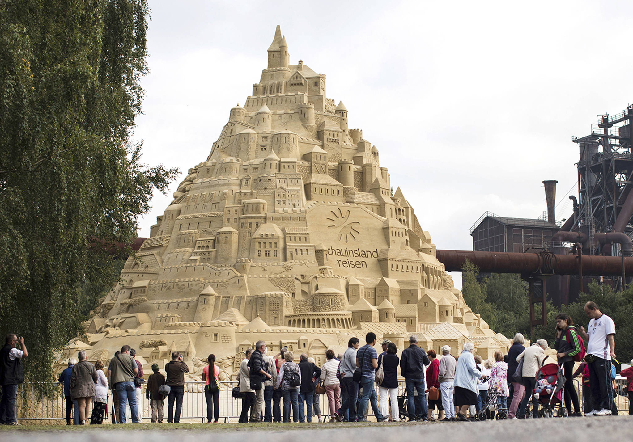 Visitors surround a sandcastle at the Landschaftspark in Duisburg, Germany, on Friday. (Marcel Kusch/dpa via AP)