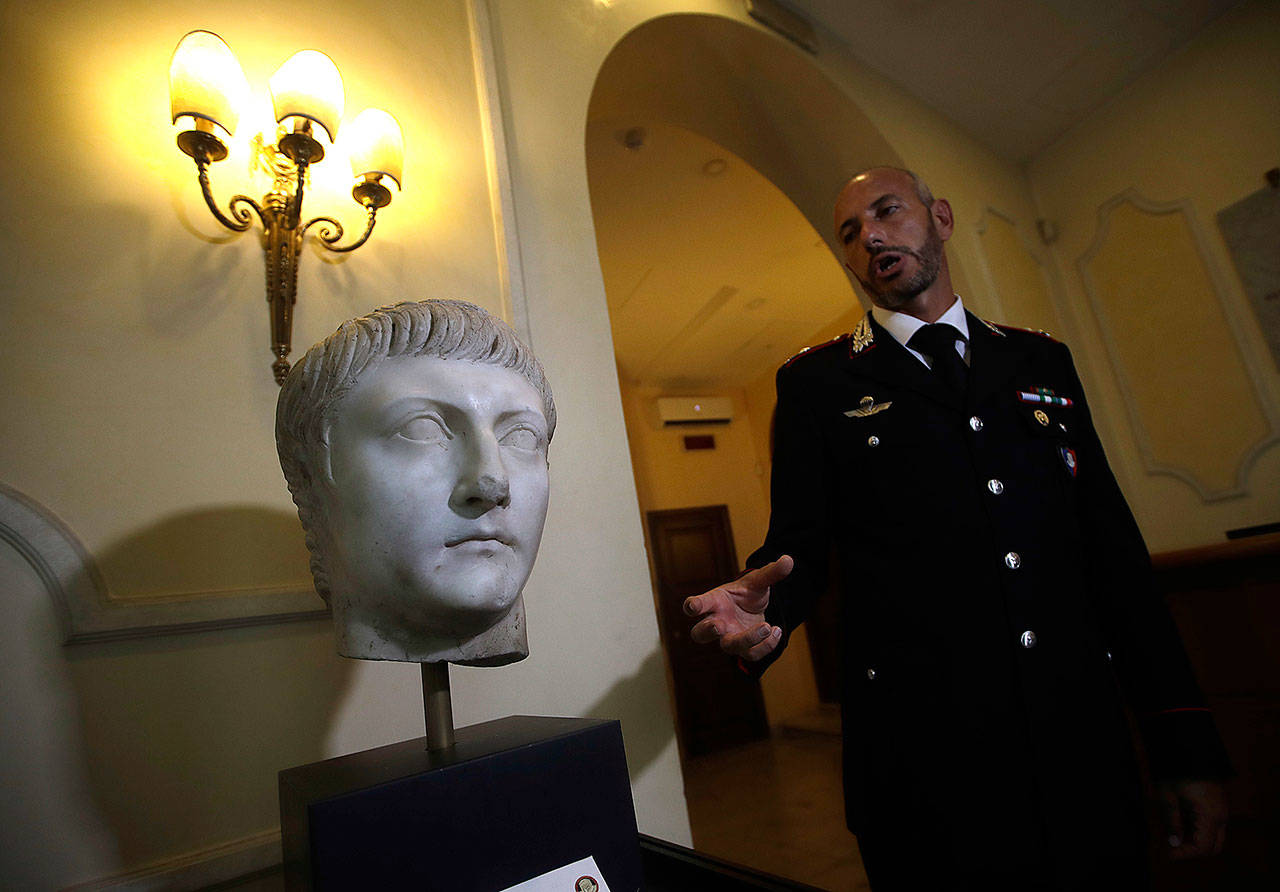 Italian Carabinieri officer Massimo Maresca shows the first century marble head at the Carabinieri barracks in Rome on Friday. (AP Photo/Alessandra Tarantino)