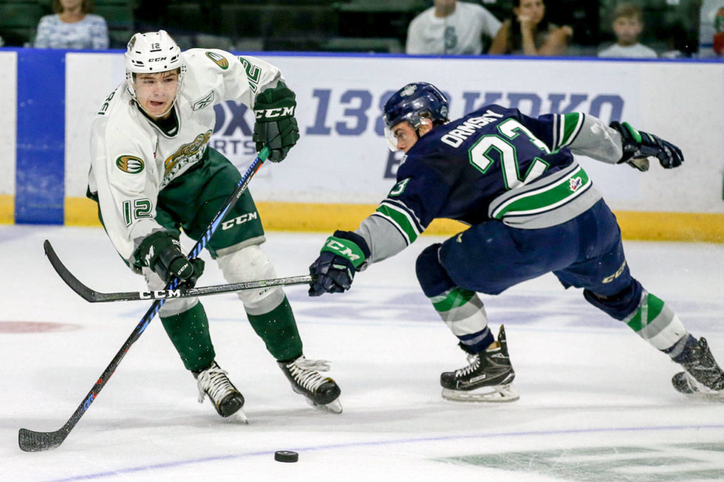 The Silvertips’ Pavel Azhgirei controls the puck with the Thunderbirds’ Luke Ormsby reaching in during the first period of a preseason game on Sept. 2, 2017, at Xfinity Arena in Everett. (Kevin Clark / The Herald)
